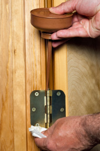 Oiling the hings of a door using an oil can