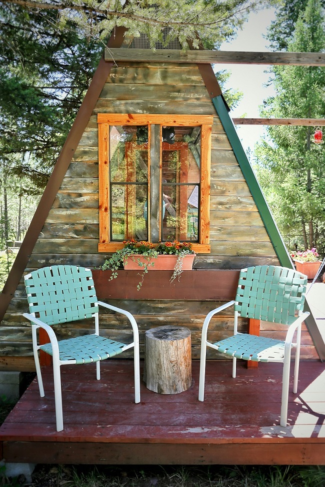 A-frame cabin with two chairs outside