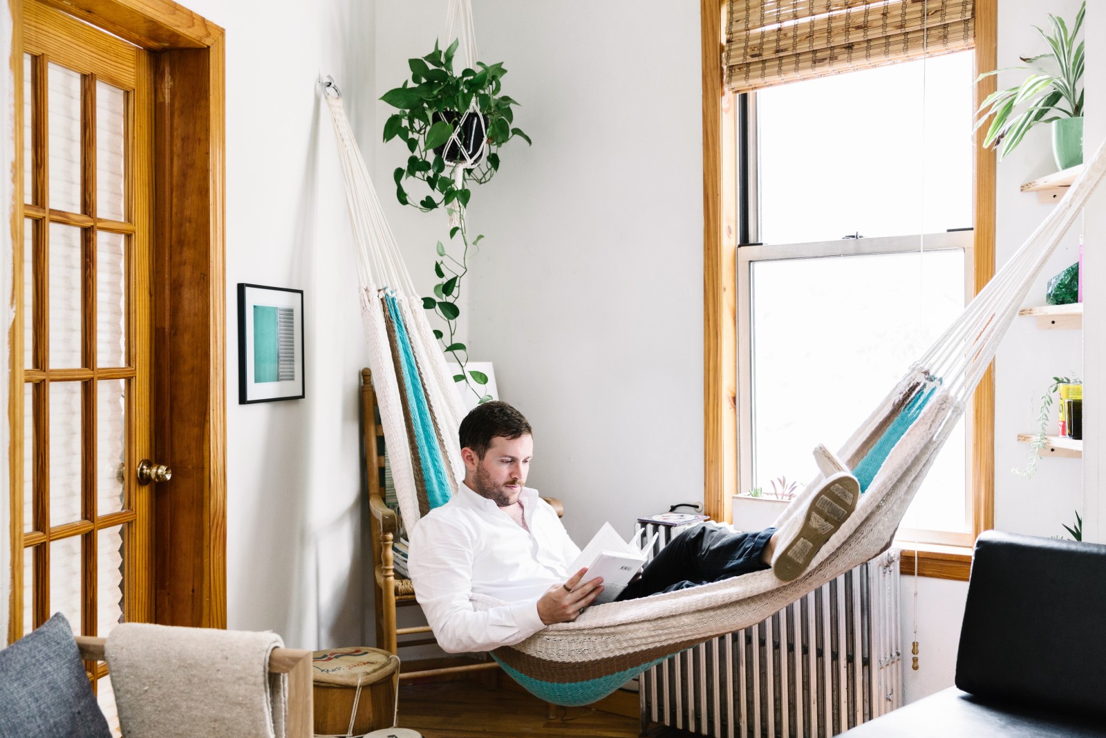 Photo of Michael Groth in hammock in his Greenpoint apartment