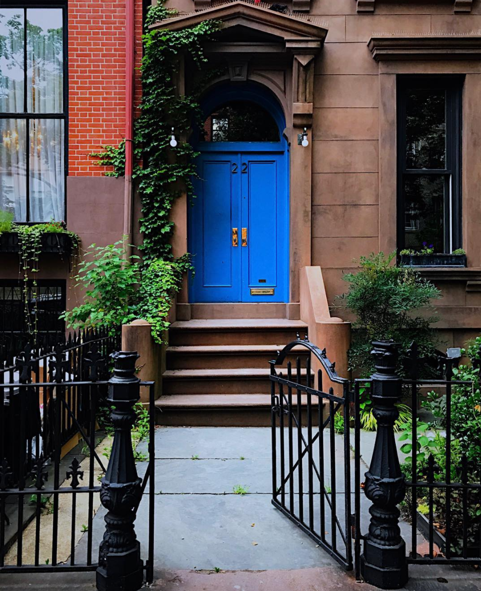 photo of a brownstone building with a blue door in new york city